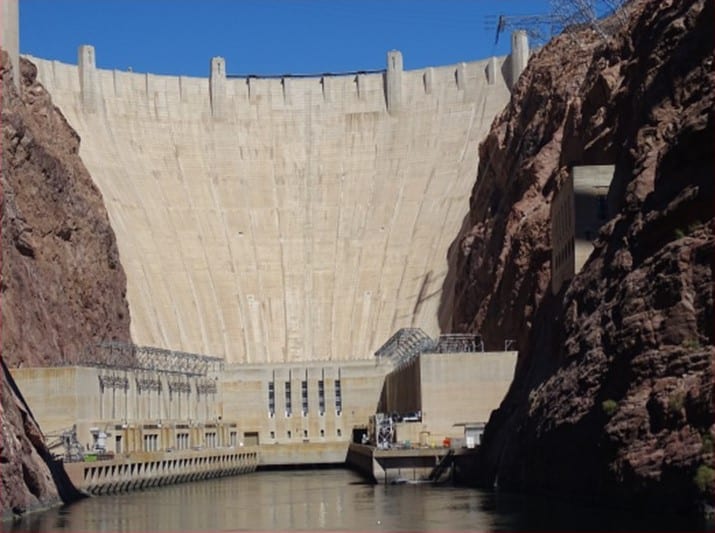 a large brick building with Hoover Dam in the background