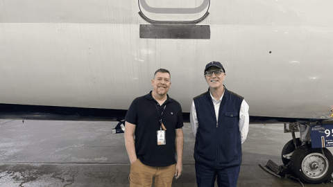 A Man Standing In Front Of A Plane
